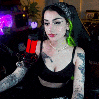 a woman with green hair is holding a microphone