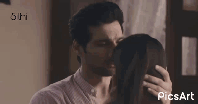 a man kissing a woman on the forehead with the words picsart visible in the corner