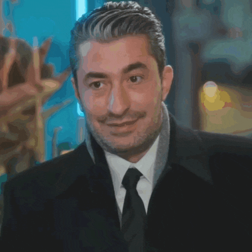 a man in a suit and tie is smiling