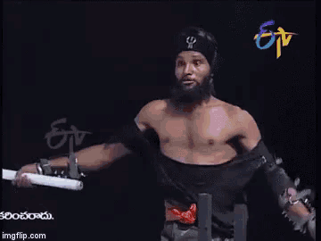 a man with a beard is standing in front of a screen that says ' etv ' on it
