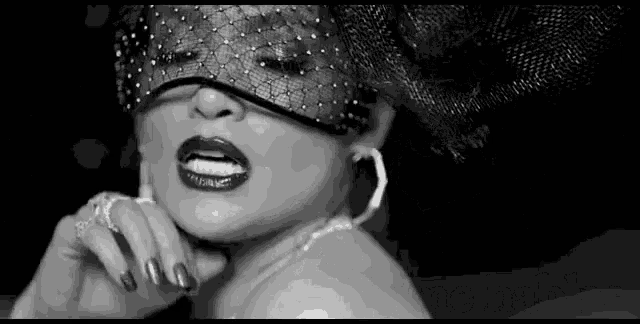 a black and white photo of a woman wearing a mask and a hat .