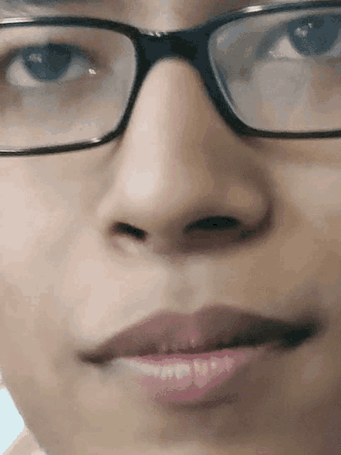 a close up of a woman 's face with glasses on