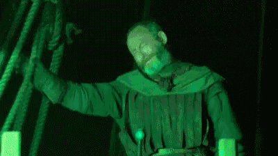 a person is swimming in the water with a green light coming out of their mouth .