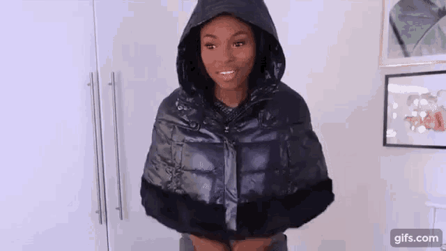 a woman is wearing a black puffer jacket with a fur trim .