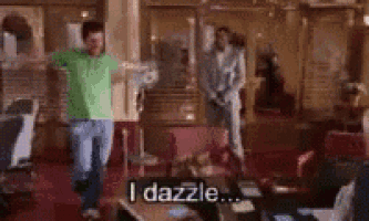a man is dancing in a living room with the words `` i dazzle '' written on the floor .