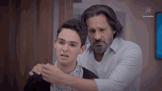 a man with a beard is standing next to a boy with the words los estrellas on the bottom right