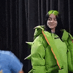 billie eilish is wearing a green costume with spikes on it .