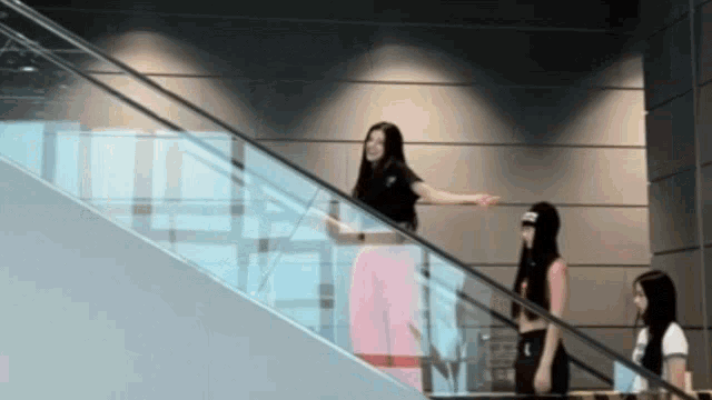 three women are standing on an escalator and one of them is wearing a crop top that says abercrombie
