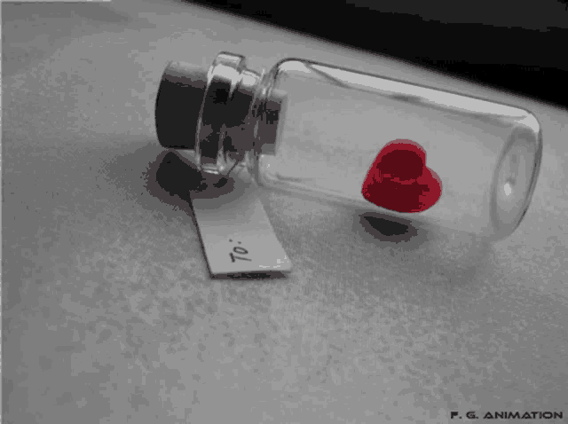 a small glass bottle with a red heart in it and a tag that says " to "