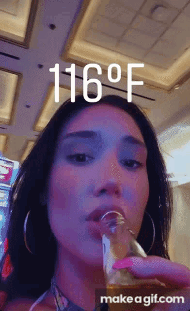 a woman drinking from a glass with the temperature reading 116 degrees fahrenheit