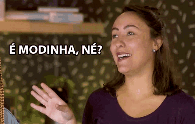 a woman says " e modinha ne " while smiling and waving her hand