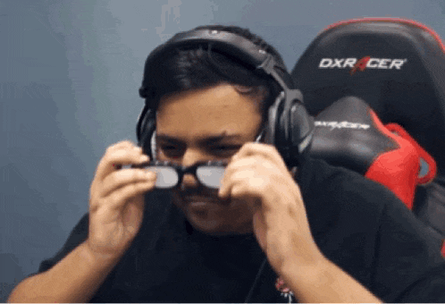 a man wearing headphones and glasses sits in a dxr cer chair