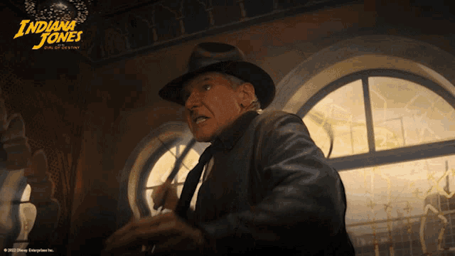 a movie poster for indiana jones shows a man in a hat and leather jacket
