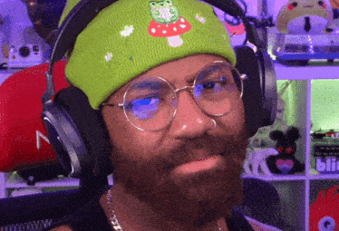 a man with a beard wearing headphones and a green beanie