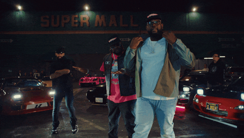 a man stands in front of a store that says super market