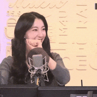 a woman sitting in front of a microphone with a sign behind her that says 91.9