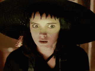 a close up of a woman wearing a black witch hat