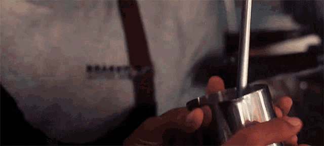 a close up of a person holding a metal object in their hand