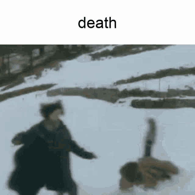 a person is laying on the ground in the snow while another person runs .