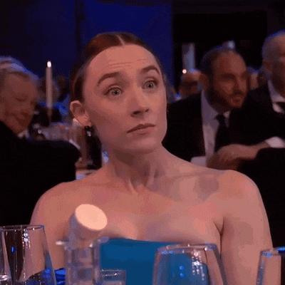 a woman in a strapless blue dress is sitting at a table with glasses of water .