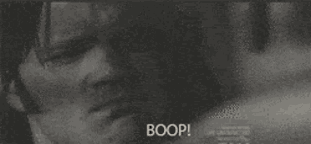 a man and a woman are kissing in a black and white photo and the man is saying boop .