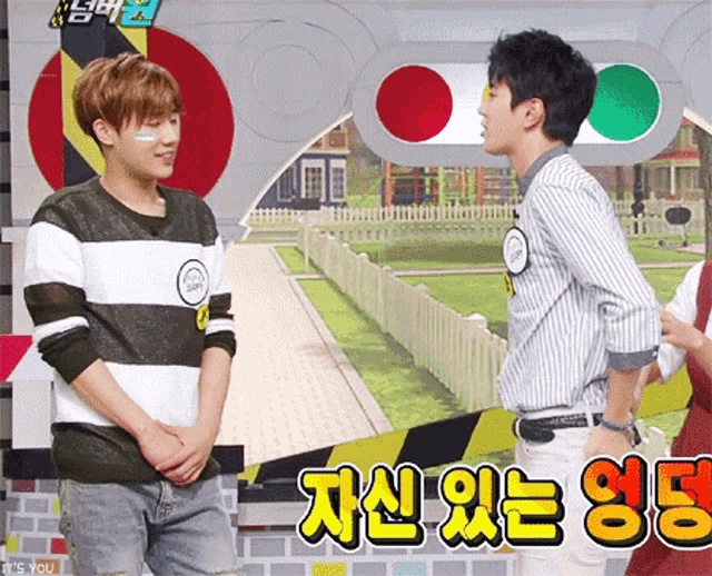 two young men are standing next to each other in front of a sign that says ' it 's you '