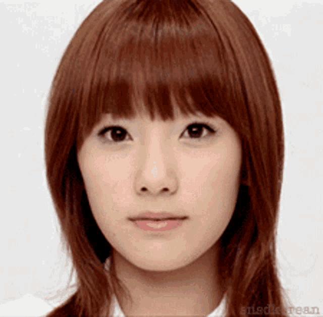 a close up of a woman 's face with a white shirt on