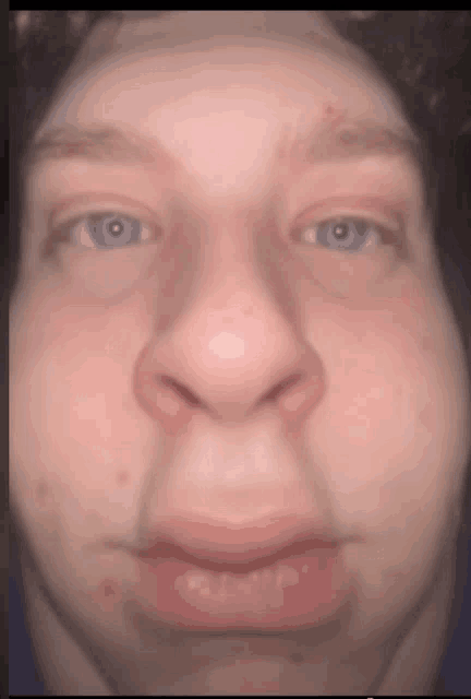 a close up of a young man 's face with blue eyes