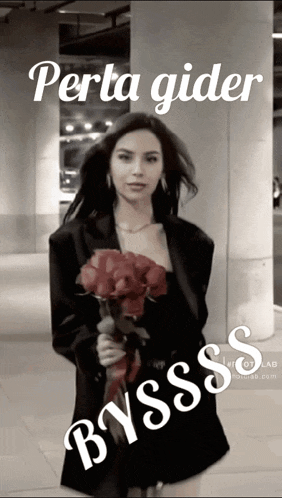 a woman in a black jacket is holding a bouquet of red roses in front of a building