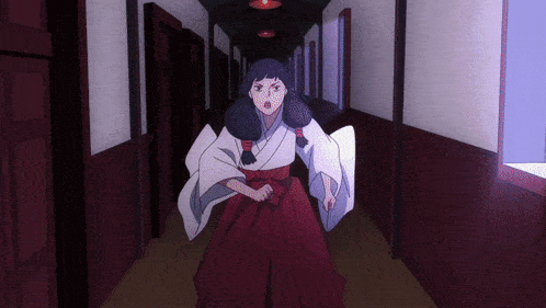 a woman in a white kimono and red skirt is running down a hallway