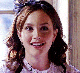 a close up of a woman 's face with a flower in her hair