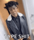 a young man wearing a leather jacket and a polo shirt is standing in front of a door and says type shit .