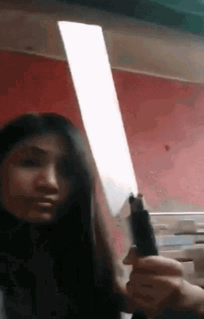 a woman is holding a large knife in front of her face