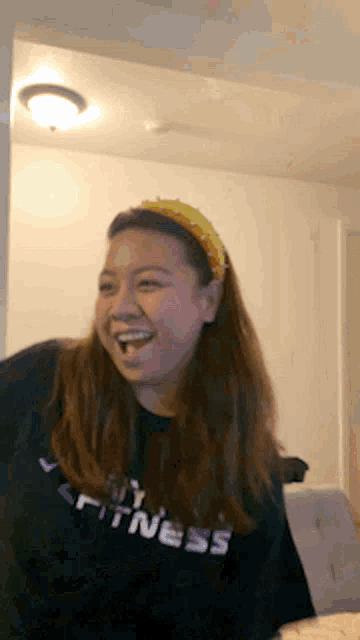 a woman wearing a black shirt that says fitness is laughing