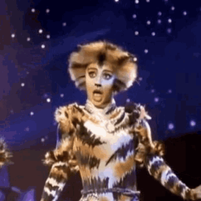 a woman in a cat costume is standing on a stage .