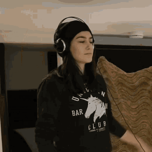 a woman wearing headphones and a black sweatshirt that says bar club