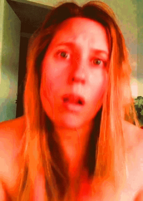 a close up of a woman 's face with a shocked look on her face
