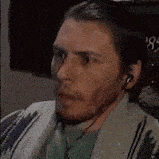 a man wearing headphones is making a funny face and the words jumpscare are on the screen .
