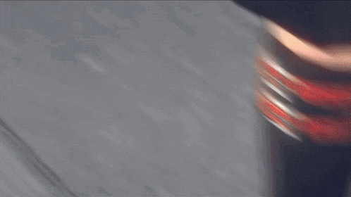 a blurred image of a person holding a wooden stick with a red stripe on it