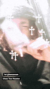 a man holding a cell phone with crosses around him