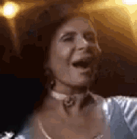 a close up of a woman 's face with her mouth open and a choker around her neck .