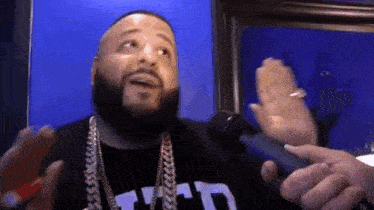 a man with a beard is holding a microphone in his hand .