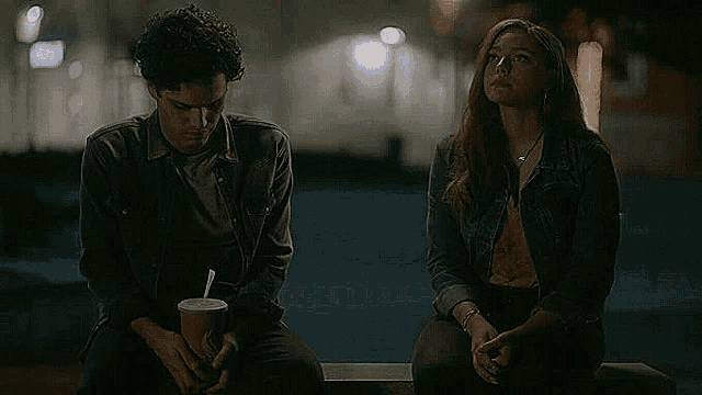a man and a woman are sitting on a bench .