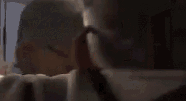 a man and a woman are kissing in a room from up .