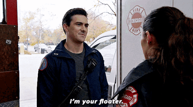 a man talking to a woman in front of a chicago fire department vehicle