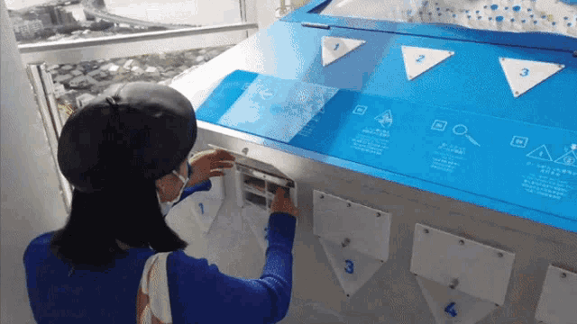 a woman wearing a face mask is looking at a display with triangles on it