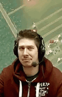 a man wearing headphones and a red hoodie is talking on a microphone .