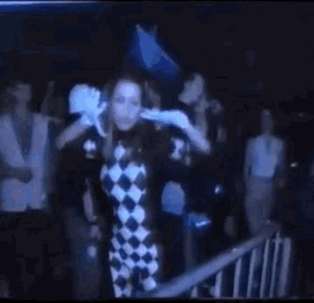 a group of people are dancing in a dark room in front of a crowd .