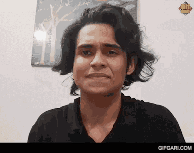 a man in a black shirt is making a funny face in front of a gif box advertisement
