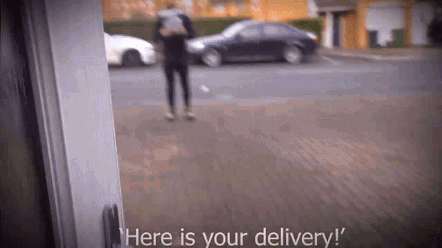 a person is standing in front of a door that says " here is your delivery " on it
